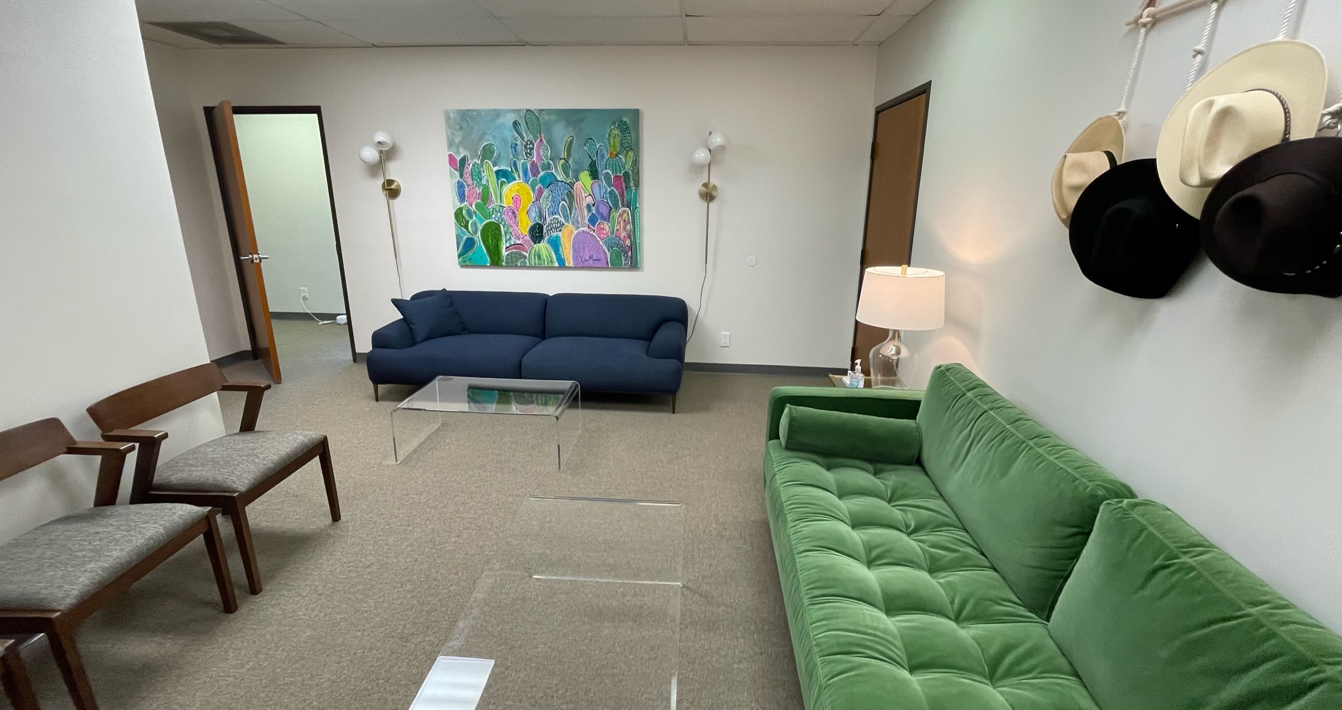 Welcoming waiting room at Fort Worth Therapy Associates with blue and green velvet sofas and colorful artwork